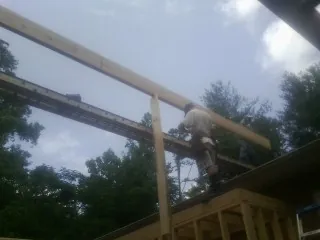 Carpenter setting a ridge beam over a new addition frame — Ice Dam Removal by Roofing Brothers in Lompoc
